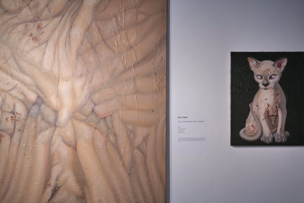 Two paintings hung on a gallery wall