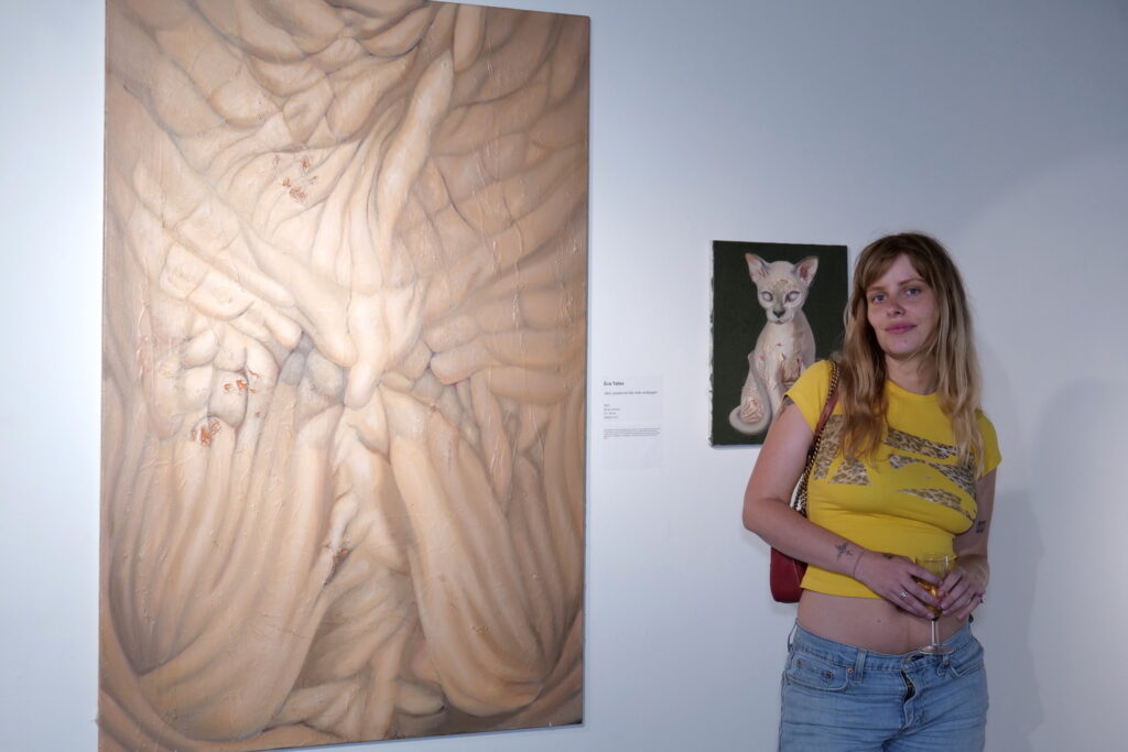 A visitor beside a large anatomical drawing of a torso
