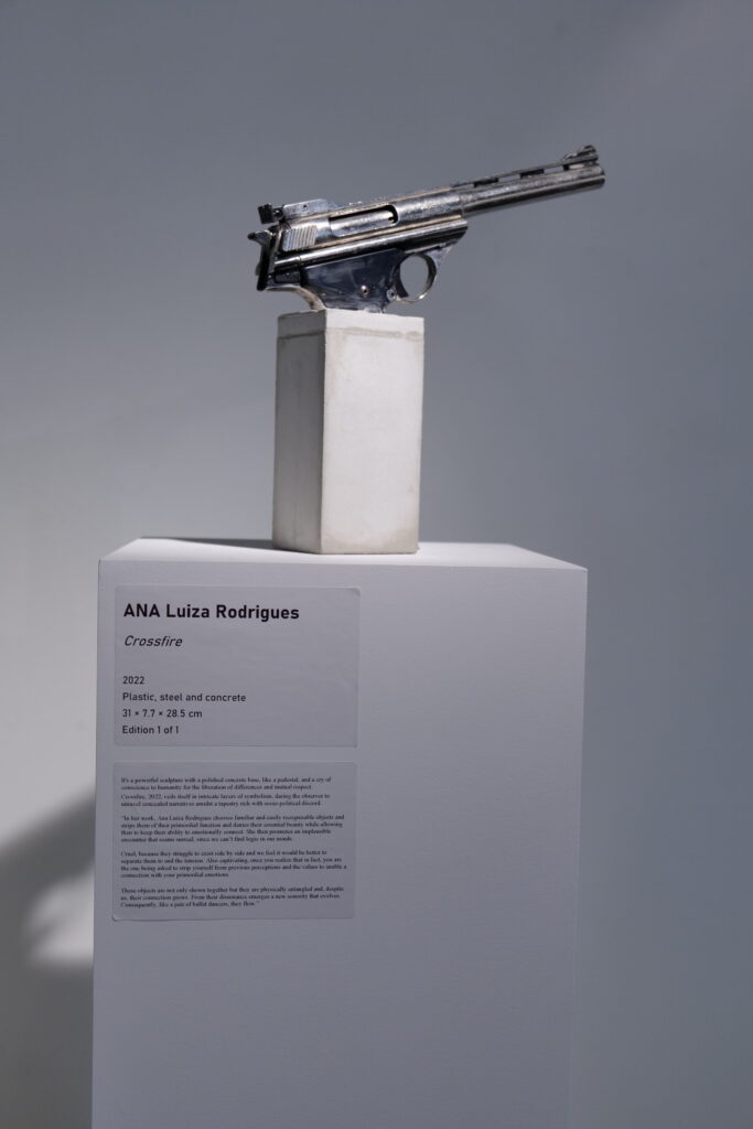 A revolver presented on a white plinth beside its wall label